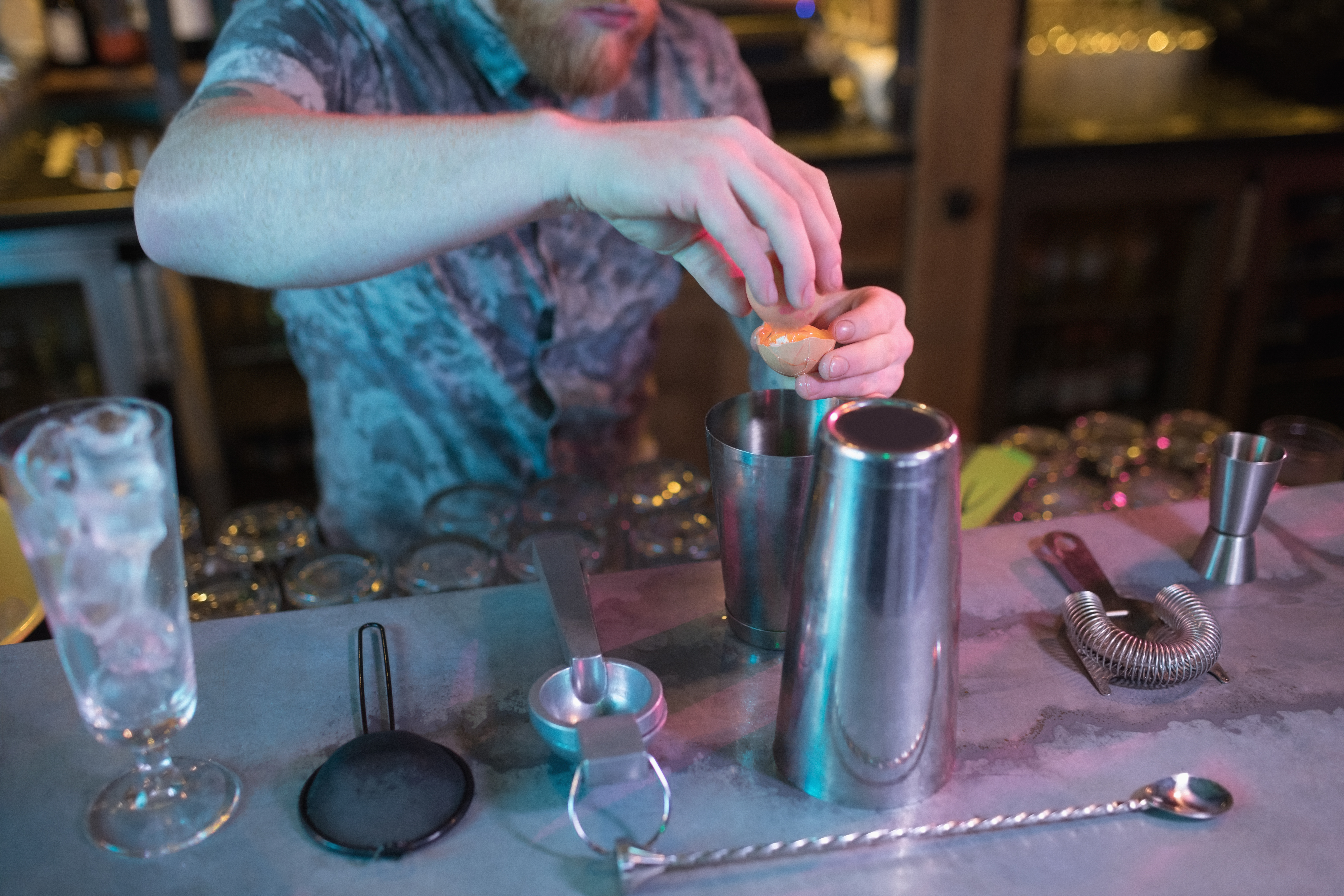 bartender-adding-egg-yolk-while-preparing-drink-counter