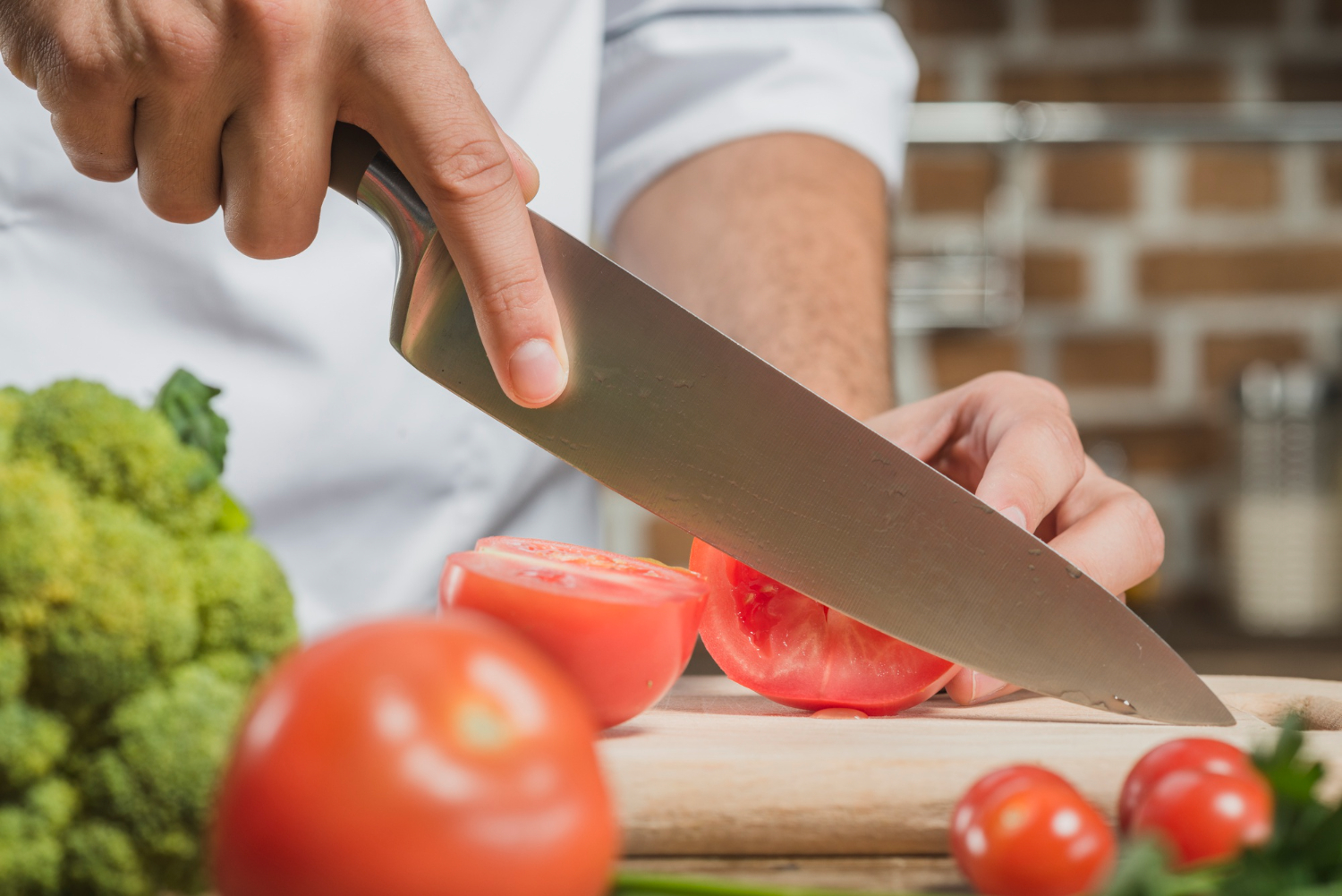 chef-s-male-hand-cutting-tomato-with-sharp-knife-board